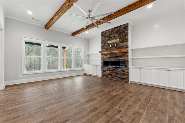 unfurnished living room with a stone fireplace, ceiling fan, beamed ceiling, and dark hardwood / wood-style floors