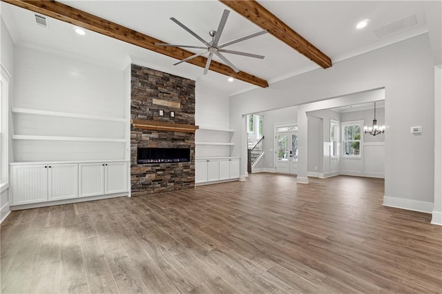 unfurnished living room featuring a fireplace, hardwood / wood-style floors, ceiling fan with notable chandelier, and built in features