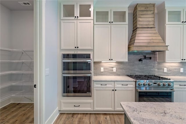6449 Snelling Mill Rd, Flowery Branch, GA 30542 - kitchen featuring appliances with stainless steel finishes, light wood-style flooring, backsplash, and light stone countertops