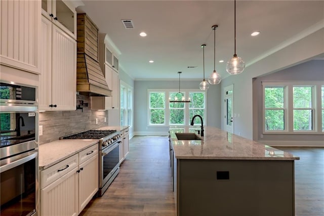 6449 Snelling Mill Rd, Flowery Branch, GA 30542 - kitchen with stainless steel appliances, a sink, an island with sink, tasteful backsplash, and dark wood-style floors