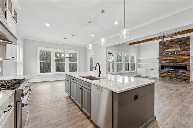 kitchen featuring hanging light fixtures, sink, a kitchen island with sink, and stainless steel appliances