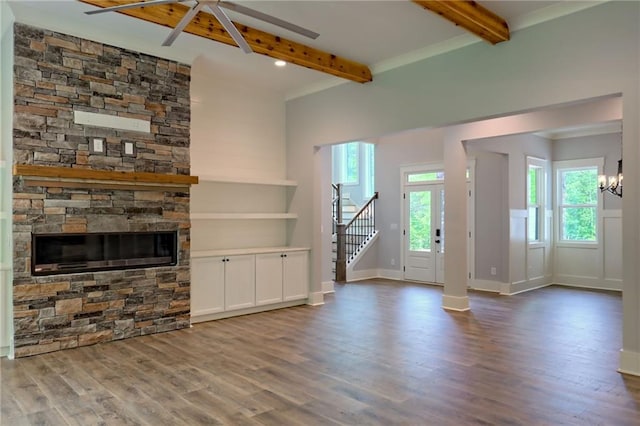 6449 Snelling Mill Rd, Flowery Branch, GA 30542 - unfurnished living room with beam ceiling, wood finished floors, stairway, a stone fireplace, and a chandelier