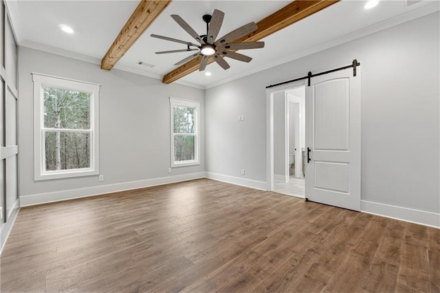 unfurnished bedroom featuring ceiling fan, a barn door, beamed ceiling, hardwood / wood-style floors, and ornamental molding