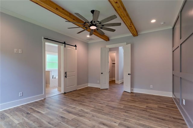 6449 Snelling Mill Rd, Flowery Branch, GA 30542 - unfurnished bedroom with beam ceiling, a barn door, wood finished floors, baseboards, and recessed lighting