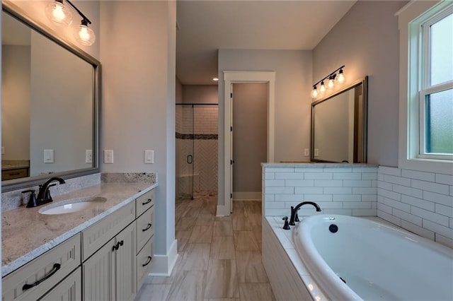 6449 Snelling Mill Rd, Flowery Branch, GA 30542 - bathroom with vanity, a garden tub, a shower stall, marble finish flooring, and baseboards