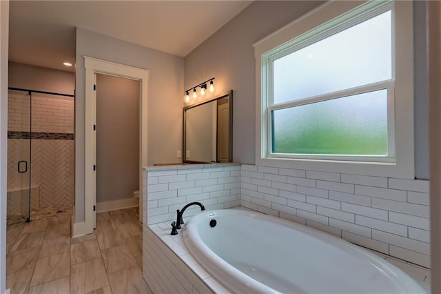 6449 Snelling Mill Rd, Flowery Branch, GA 30542 - bathroom with a garden tub, a stall shower, toilet, and baseboards