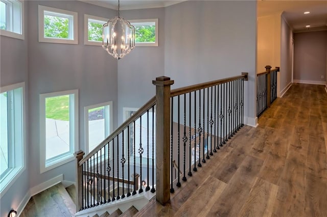 6449 Snelling Mill Rd, Flowery Branch, GA 30542 - stairway with a chandelier, wood finished floors, and baseboards