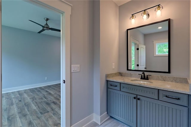 6449 Snelling Mill Rd, Flowery Branch, GA 30542 - bathroom with a ceiling fan, vanity, wood finished floors, and baseboards