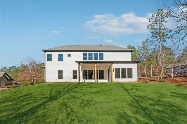 rear view of property featuring a yard and ceiling fan