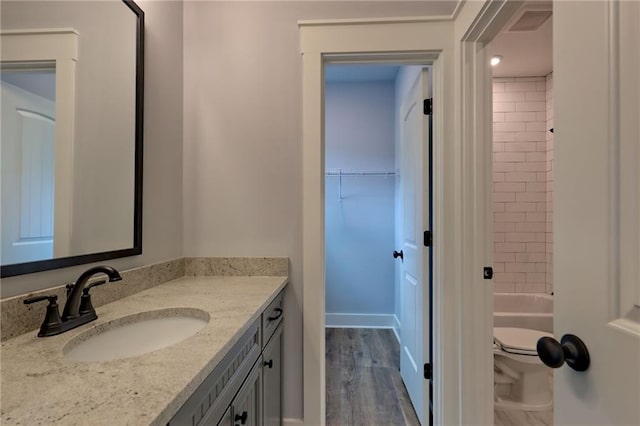 6449 Snelling Mill Rd, Flowery Branch, GA 30542 - bathroom featuring vanity, toilet, wood finished floors, and shower / tub combination