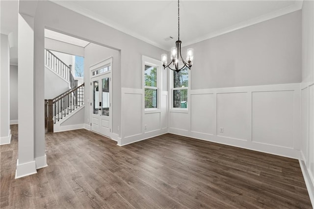 unfurnished dining area featuring crown molding, dark hardwood / wood-style flooring, and a chandelier