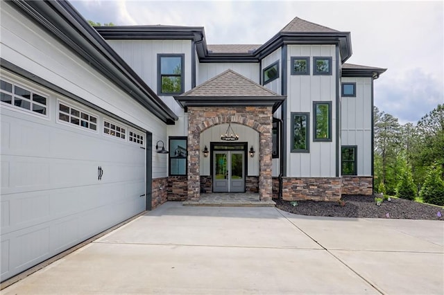 6449 Snelling Mill Rd, Flowery Branch, GA 30542 - view of front of home with stone siding, french doors, board and batten siding, roof with shingles, and driveway