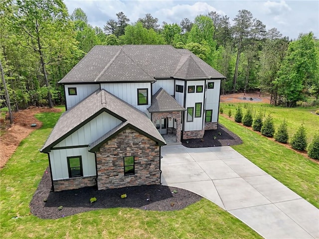6449 Snelling Mill Rd, Flowery Branch, GA 30542 - view of front of house with roof with shingles, stone siding, a front yard, board and batten siding, and driveway