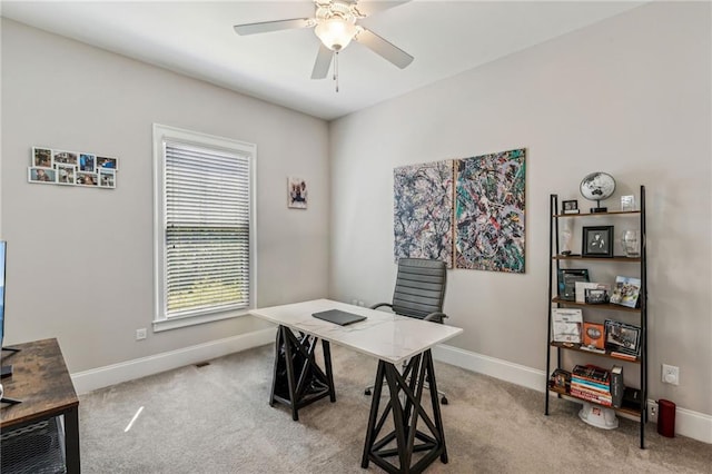 carpeted home office featuring ceiling fan