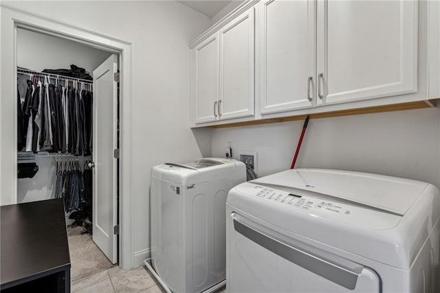 washroom featuring cabinets, washer and dryer, and light tile patterned floors