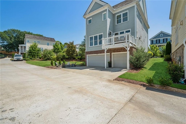 view of front of home featuring a balcony, a garage, and a front yard