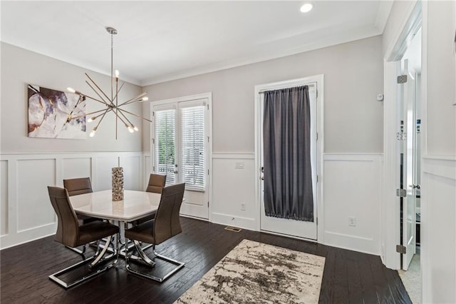 dining room with ornamental molding, dark hardwood / wood-style floors, and a chandelier