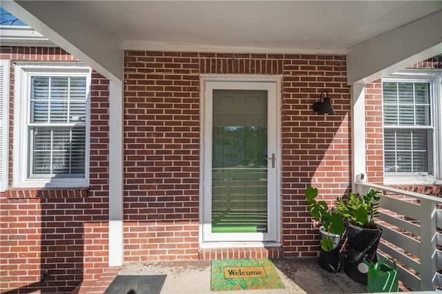 doorway to property with brick siding