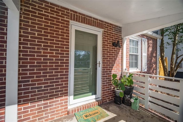 property entrance featuring brick siding