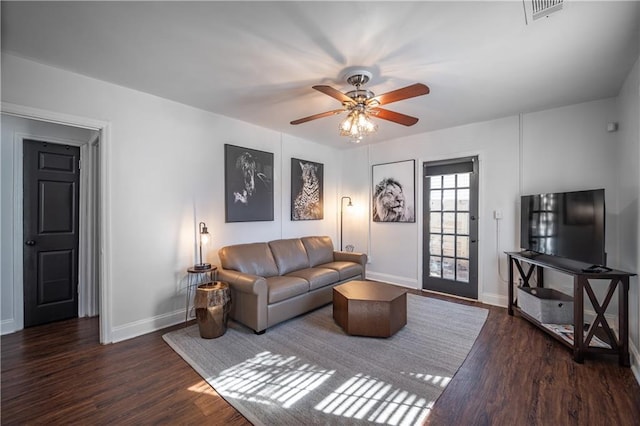 living area with a ceiling fan, visible vents, baseboards, and wood finished floors