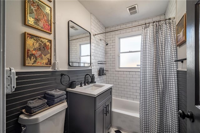 bathroom featuring visible vents, shower / tub combo with curtain, vanity, and toilet