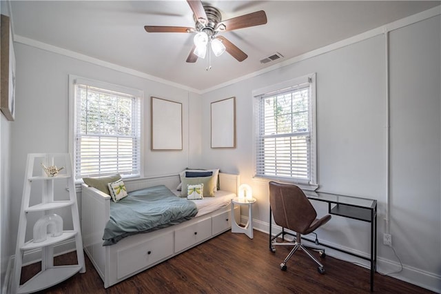 bedroom featuring crown molding, visible vents, dark wood-type flooring, a ceiling fan, and baseboards