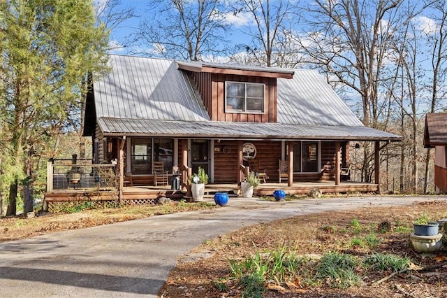 log cabin featuring covered porch