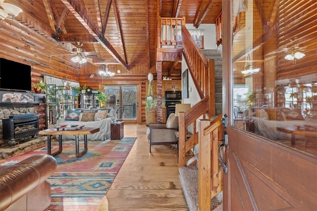 living room featuring high vaulted ceiling, hardwood / wood-style flooring, log walls, beam ceiling, and wood ceiling