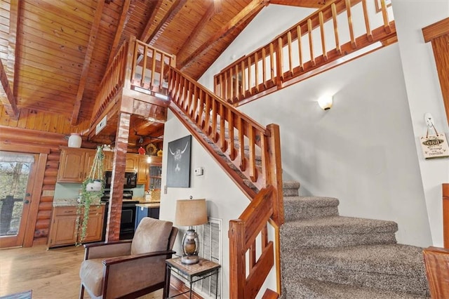 stairs featuring beam ceiling, rustic walls, high vaulted ceiling, wood ceiling, and hardwood / wood-style flooring