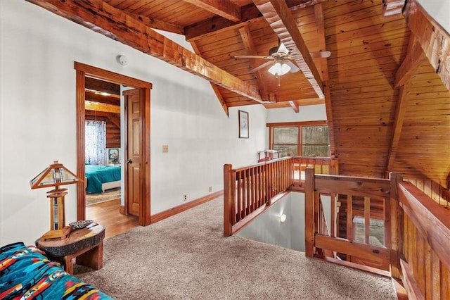 hall with lofted ceiling with beams, light colored carpet, and wood ceiling