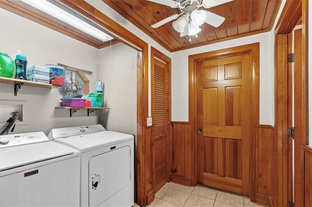 clothes washing area featuring ornamental molding, wood ceiling, ceiling fan, wooden walls, and washing machine and dryer