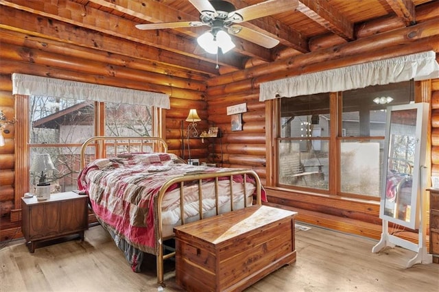 bedroom featuring ceiling fan, beam ceiling, light wood-type flooring, and wood ceiling