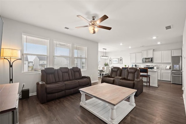 living room with ceiling fan and dark hardwood / wood-style floors