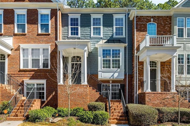 townhome / multi-family property featuring stairway and brick siding