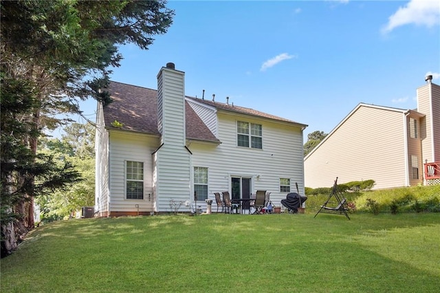 rear view of house with cooling unit and a yard