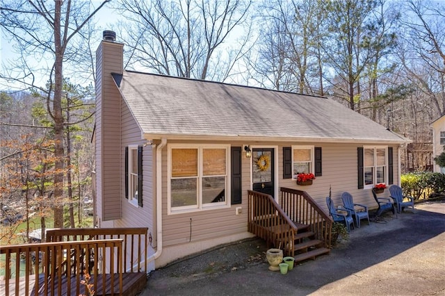 view of front of property with a chimney and roof with shingles