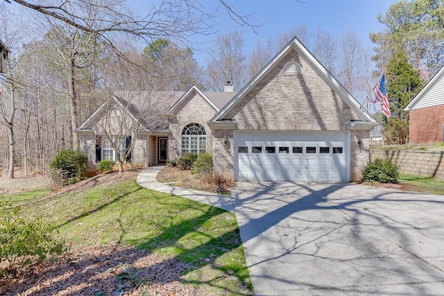 view of front of home with a front yard, driveway, a chimney, a garage, and brick siding