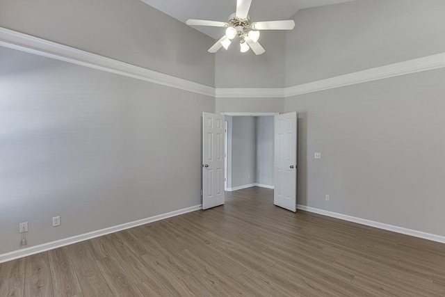 unfurnished room with high vaulted ceiling, a ceiling fan, baseboards, and wood finished floors