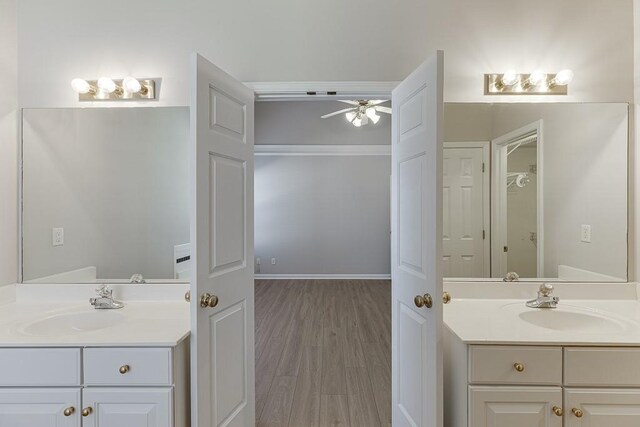 bathroom with two vanities, a ceiling fan, and a sink