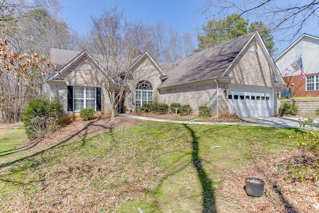 view of front of home with a garage, brick siding, concrete driveway, and a front yard