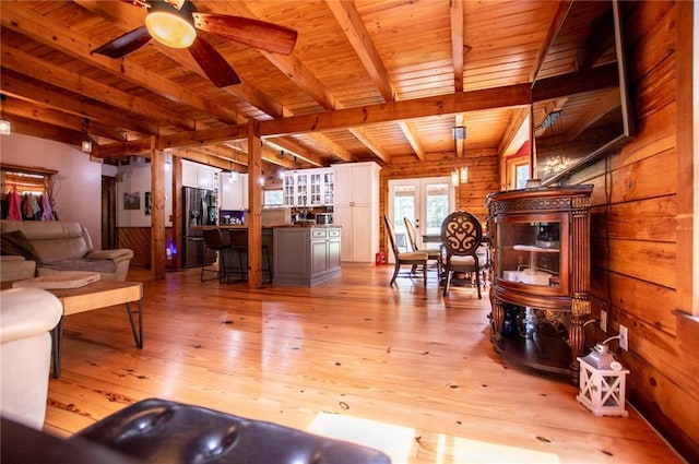 living area featuring light wood-style floors, a ceiling fan, beam ceiling, and wooden ceiling
