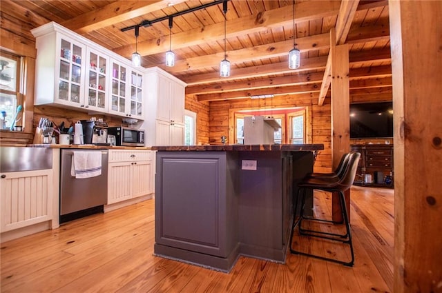kitchen featuring wooden walls, stainless steel appliances, a healthy amount of sunlight, and wood ceiling