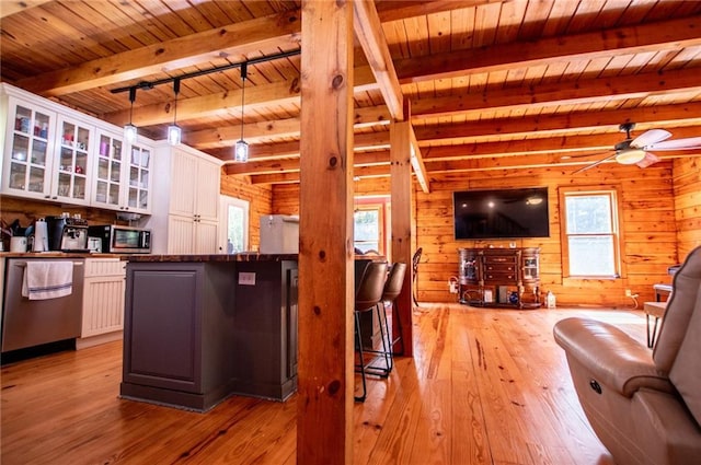 living room featuring wooden ceiling, plenty of natural light, light wood finished floors, and beam ceiling