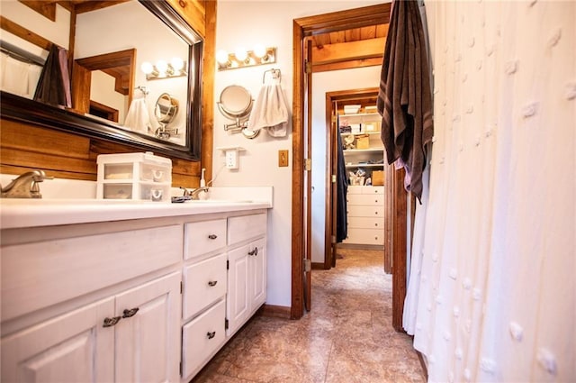 full bath with baseboards and vanity