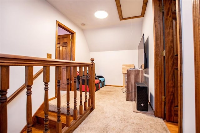 interior space featuring carpet floors, baseboards, lofted ceiling, and attic access