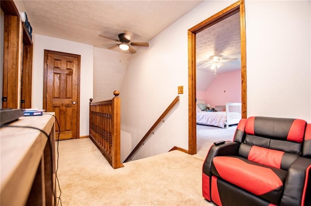 interior space featuring light colored carpet, a ceiling fan, a textured ceiling, and lofted ceiling
