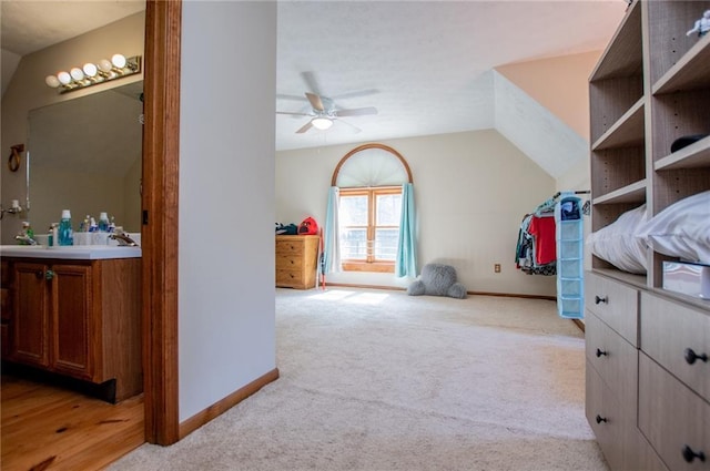 walk in closet with ceiling fan, light carpet, and vaulted ceiling