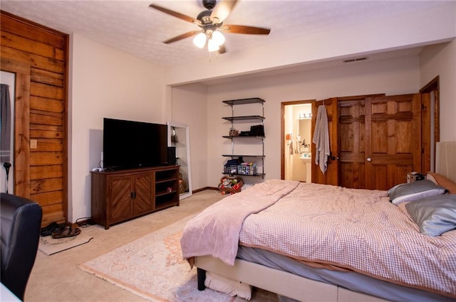 bedroom featuring a ceiling fan, visible vents, carpet, and ensuite bath