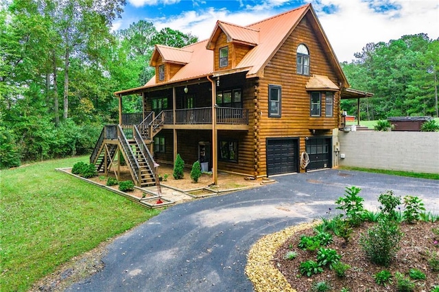 view of front of property featuring driveway, metal roof, a garage, log exterior, and stairs