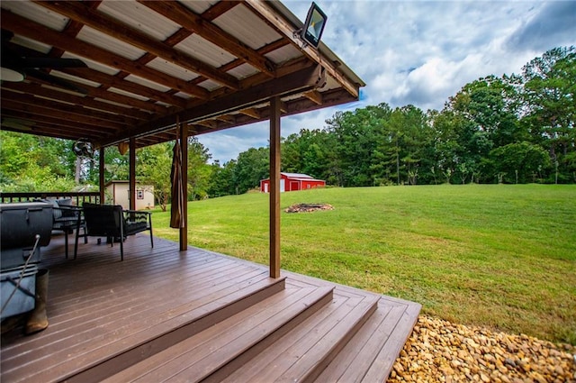wooden terrace with an outbuilding, a yard, a storage shed, and outdoor dining space